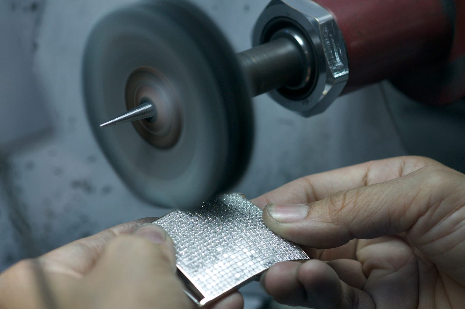 A diamond-set plate is brought to the polishing wheel.