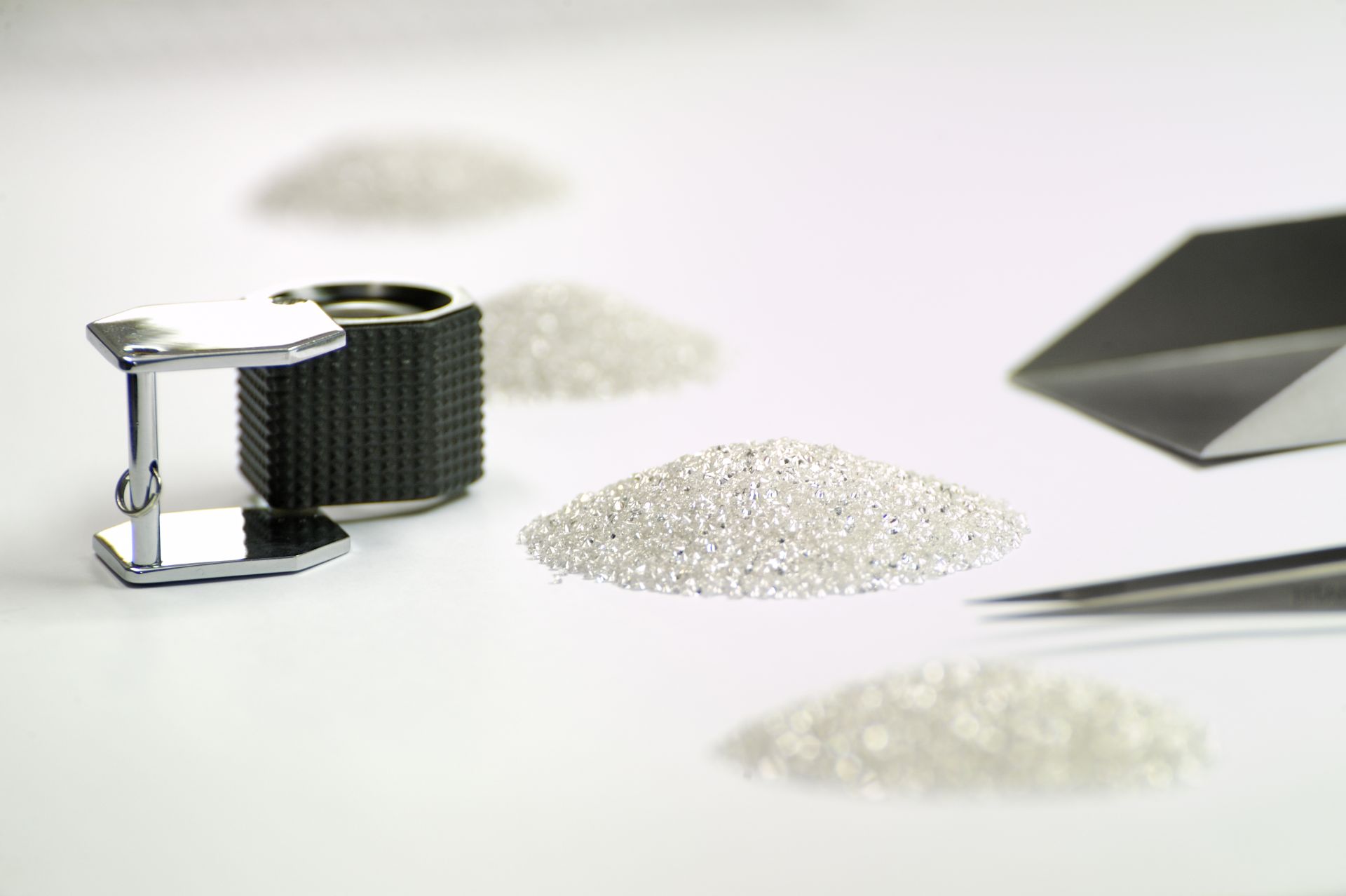 Natural diamonds resting on dark cloth, lit from above.